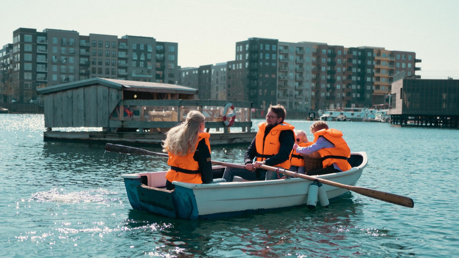 Tre gæster i redningsveste ror ud mod Blue Raft