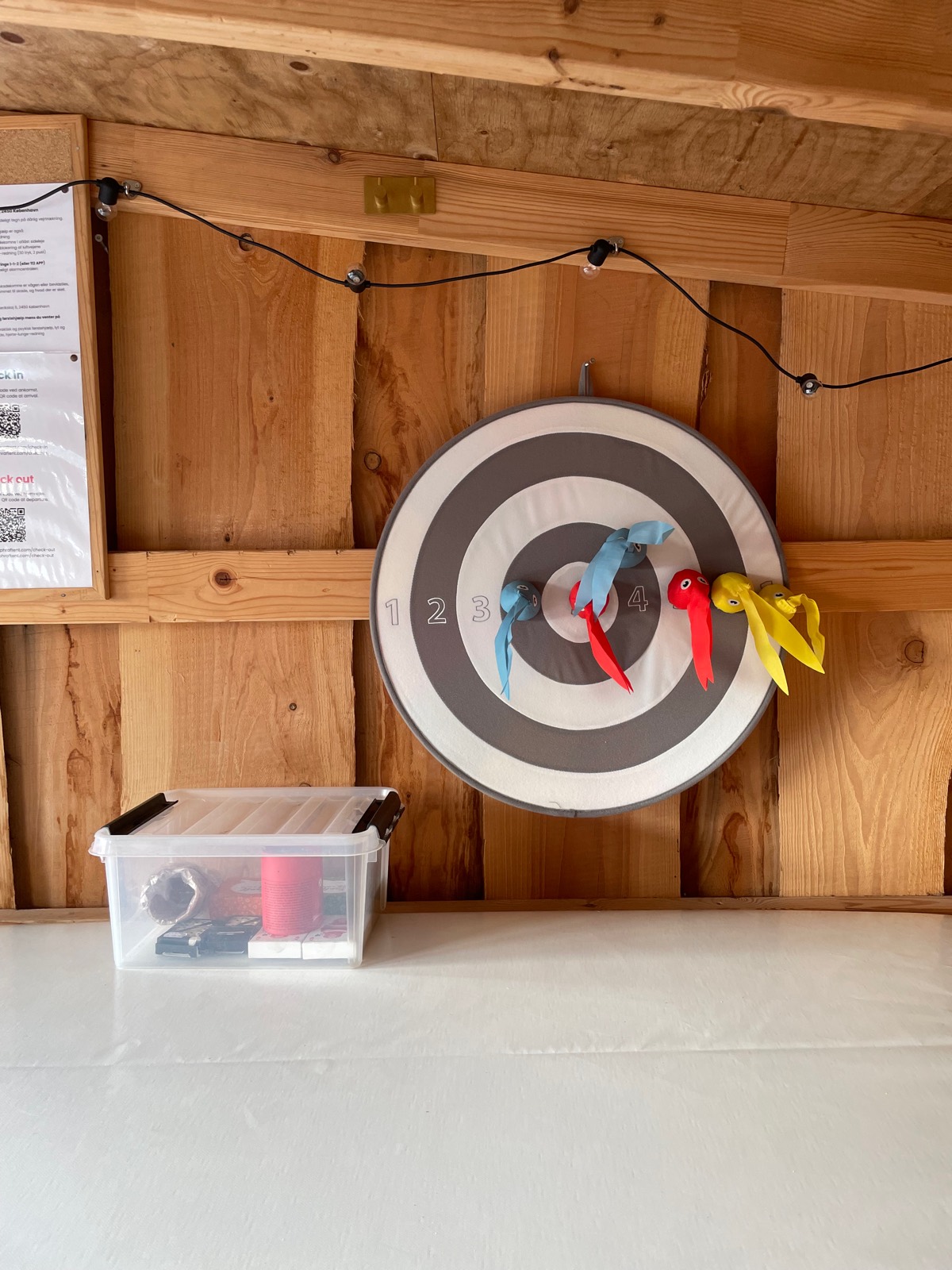 Dartskive i velcro og en kasse med spil i kabinen