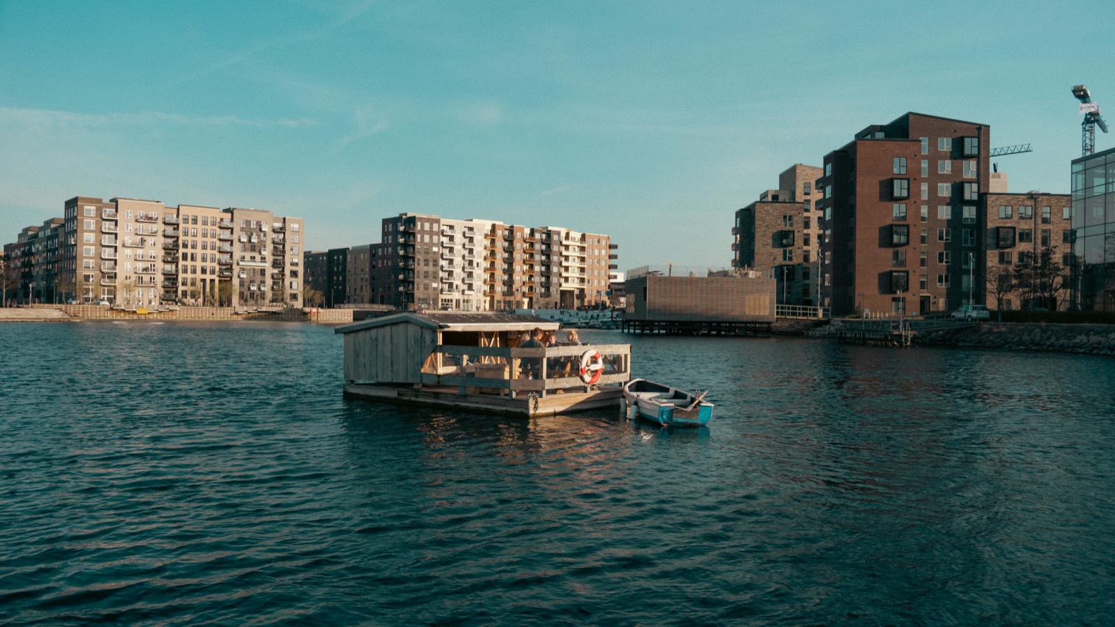 Blue Raft 1 og robåden i havnen en solrig aften