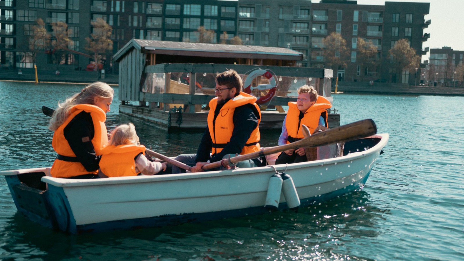 En familie i redningsveste ror tæt forbi Blue Raft