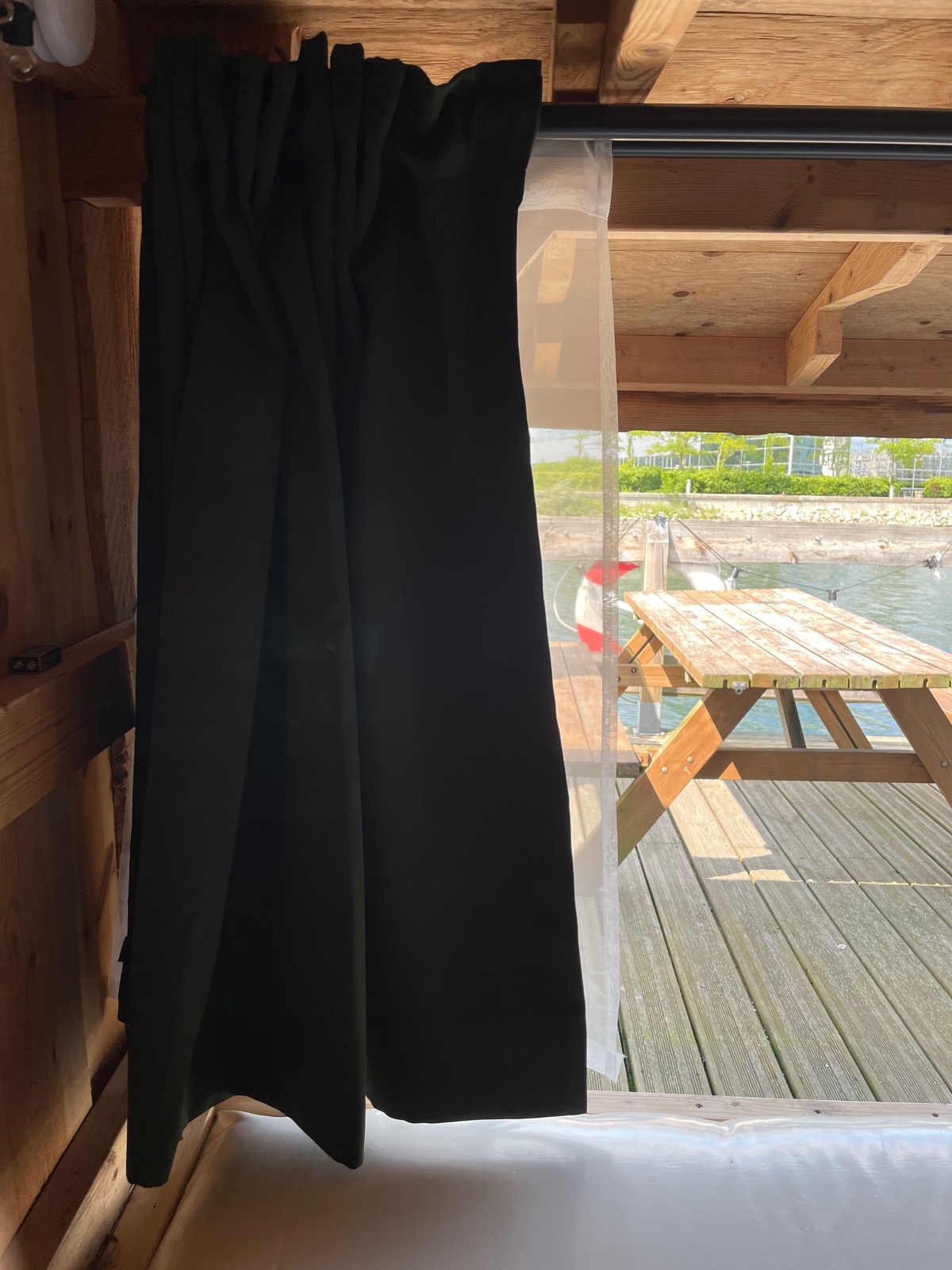 Et mørklægningsgardin trukket til side med bordet på dækket bagved