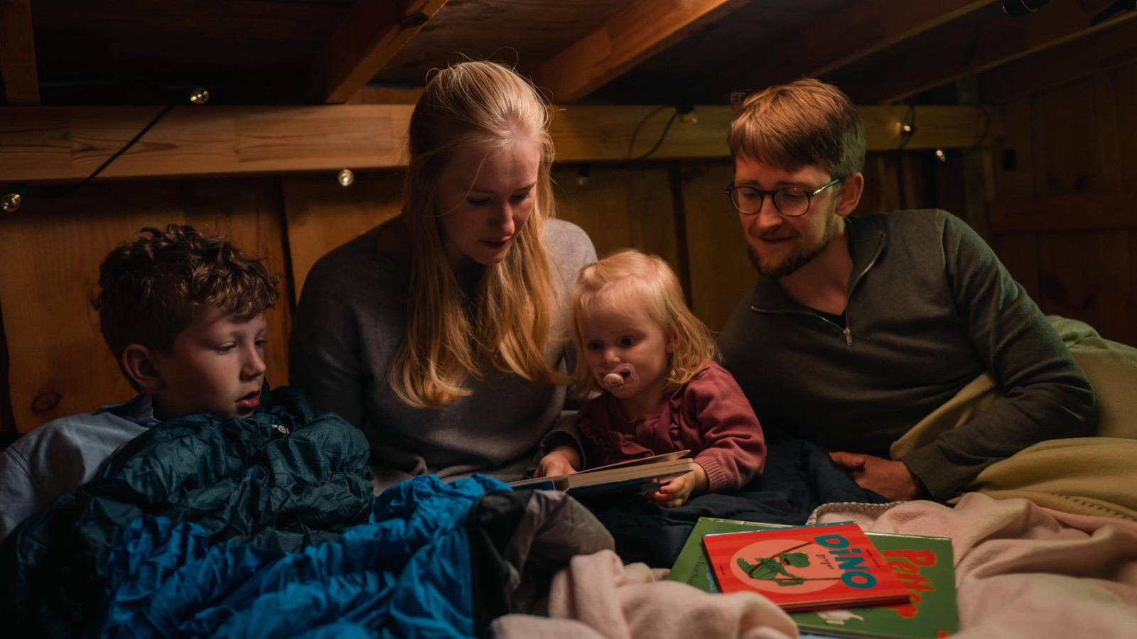En familie læser sammen i sovekabinen om aftenen