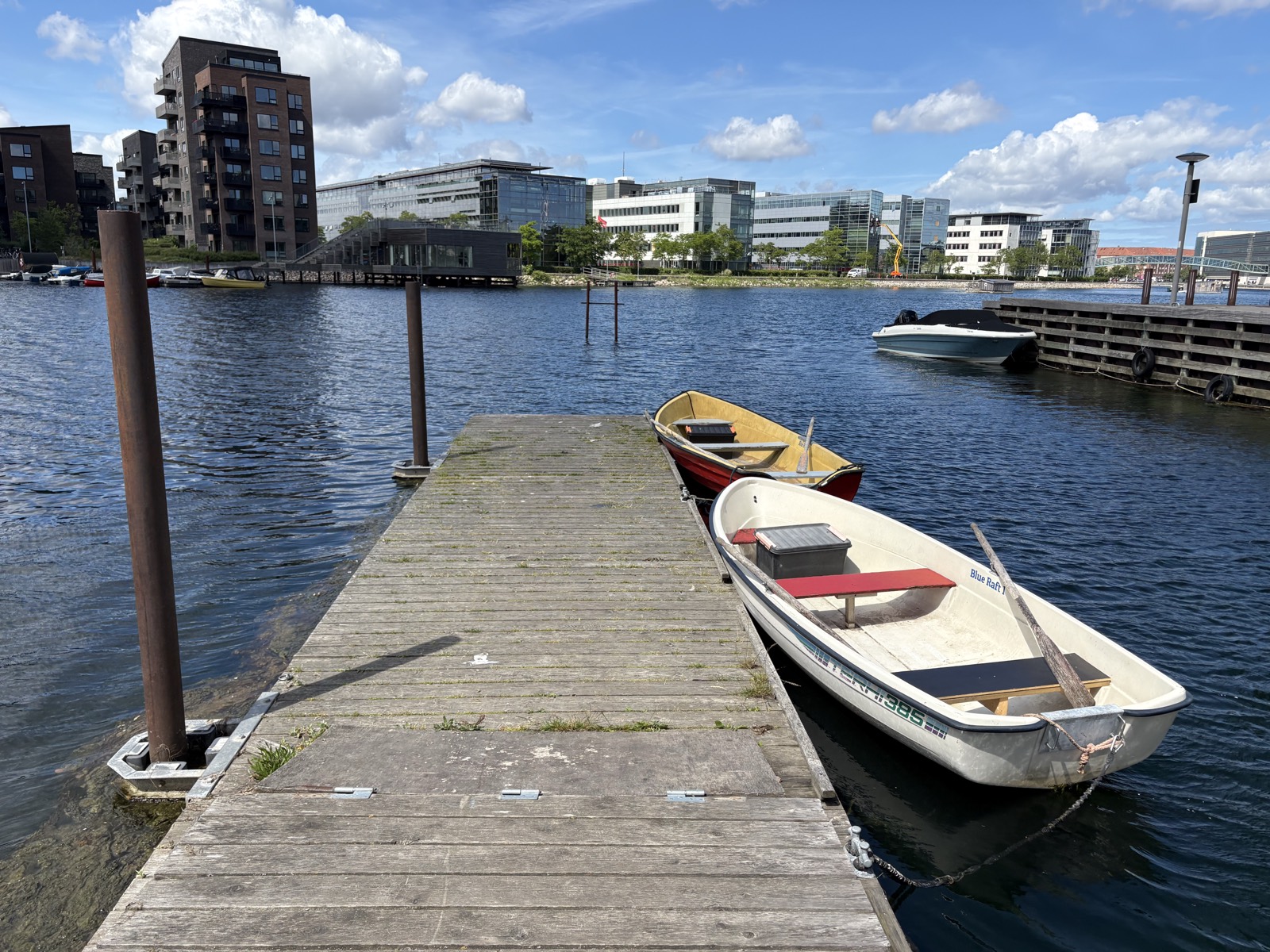 Den hvide robåd ved broen i solskin