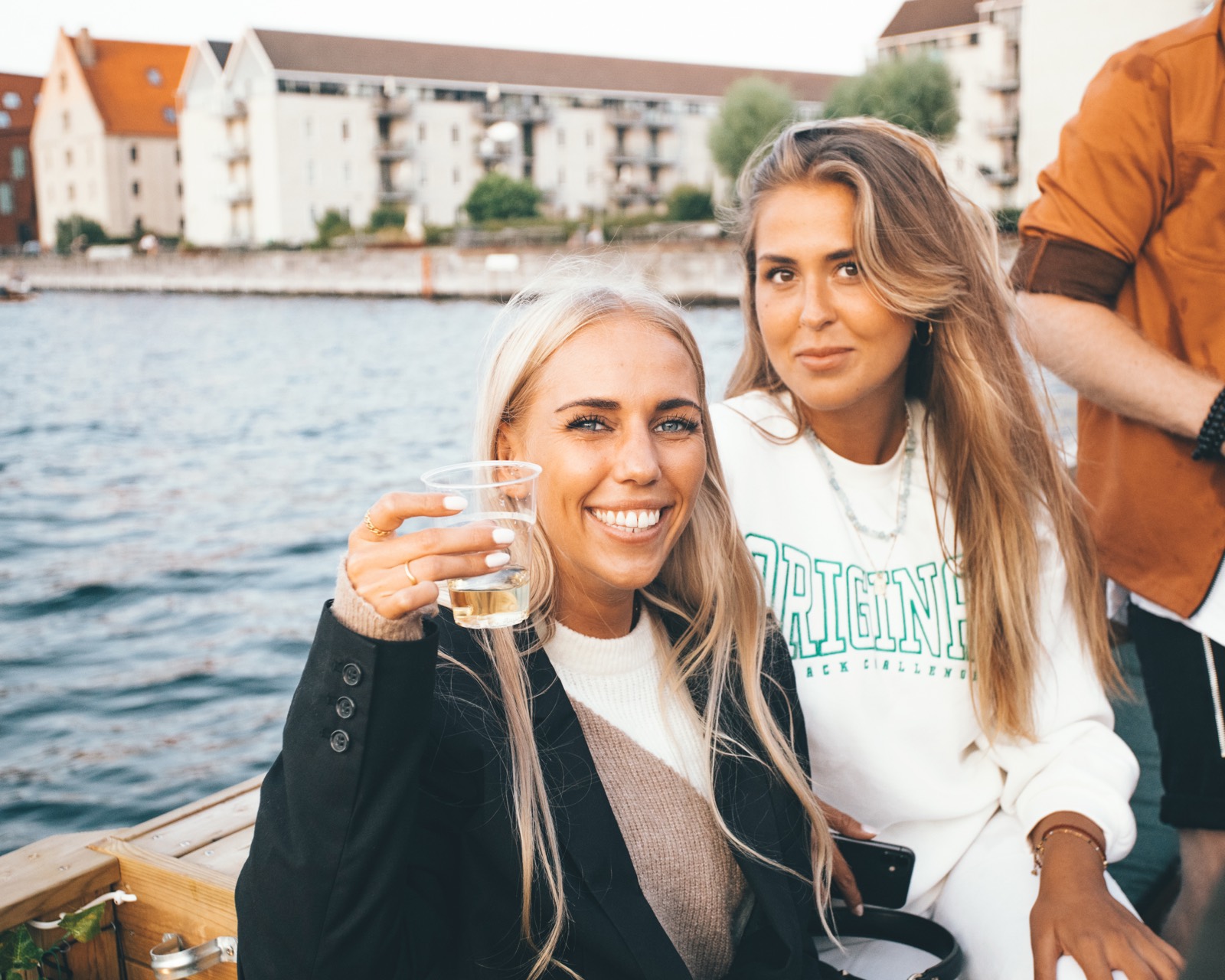 To smilende piger nyder en drink på green raft tømmerflåde