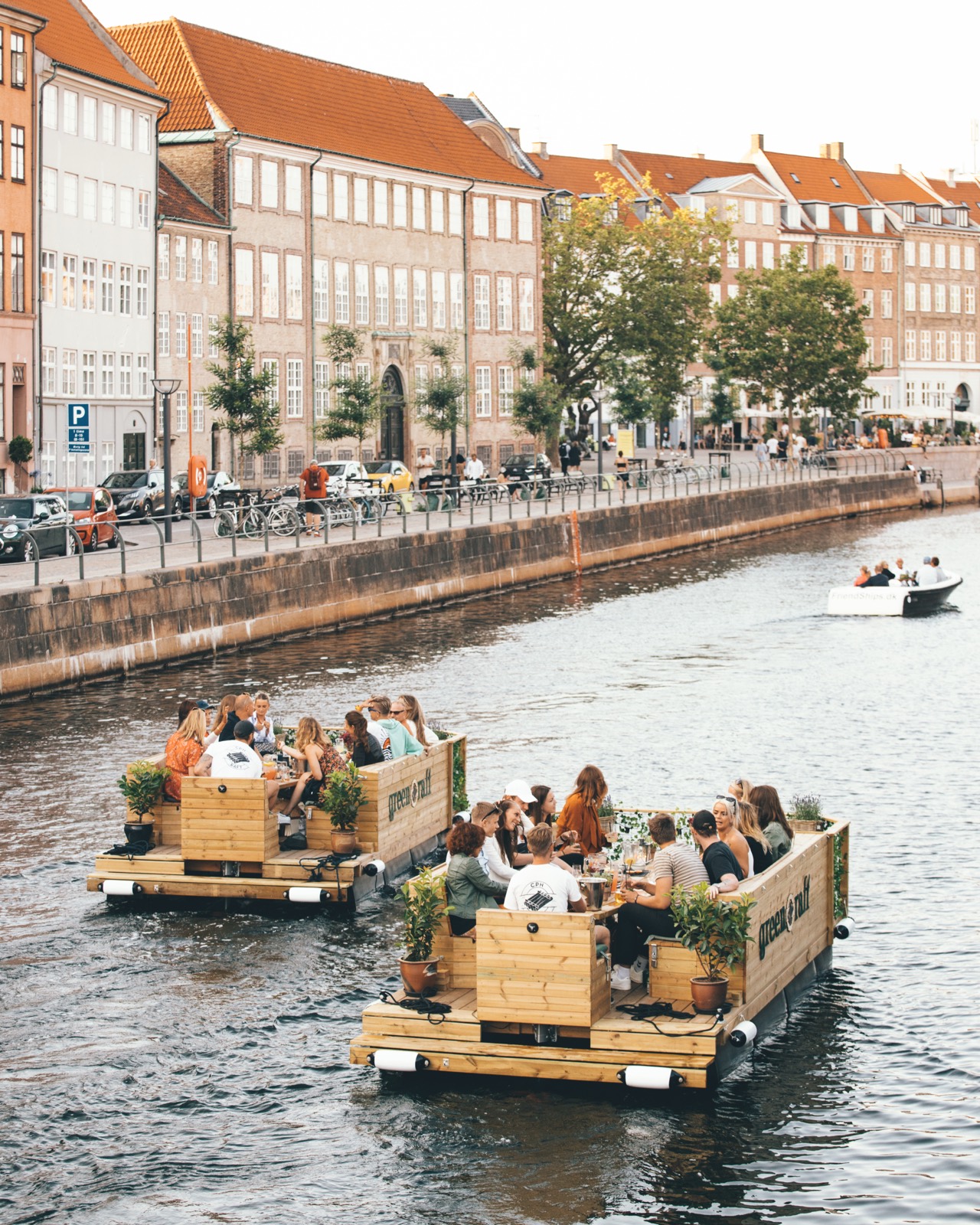 To Green Raft-tømmerflåder fulde af gæster sejler side om side i havnen
